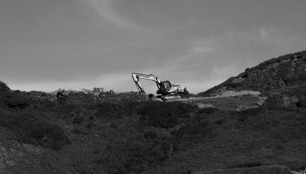 a black and white photo of a bulldozer on a hill