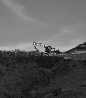 a black and white photo of a bulldozer on a hill
