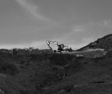 a black and white photo of a bulldozer on a hill